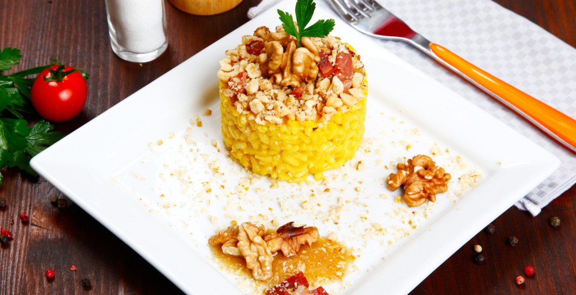 risotto with walnuts, saffron, speck on a dish